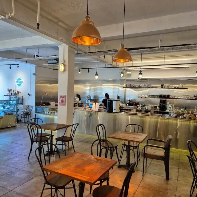 The brushed-chrome counter and copper pendant lamps inside the cafe