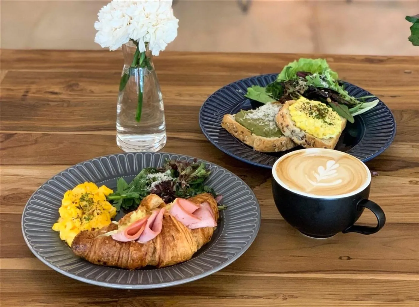 A brunch spread with a latte on a wooden table
